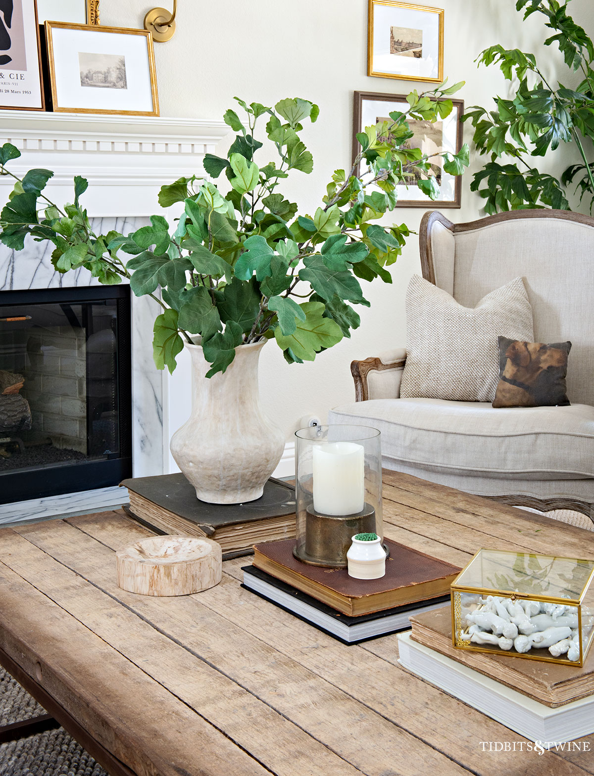 Coffee table styled with a mix of materials including wood, glass, ceramic, and metal for a layered, collected look