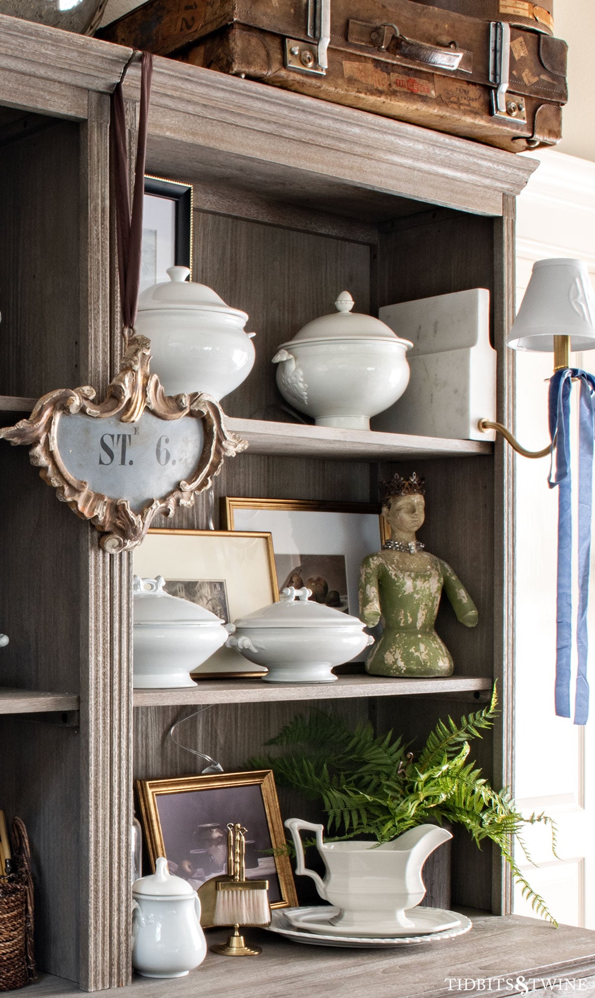 Silent butler styled on open shelving with ironstone, framed art, and collected antiques.