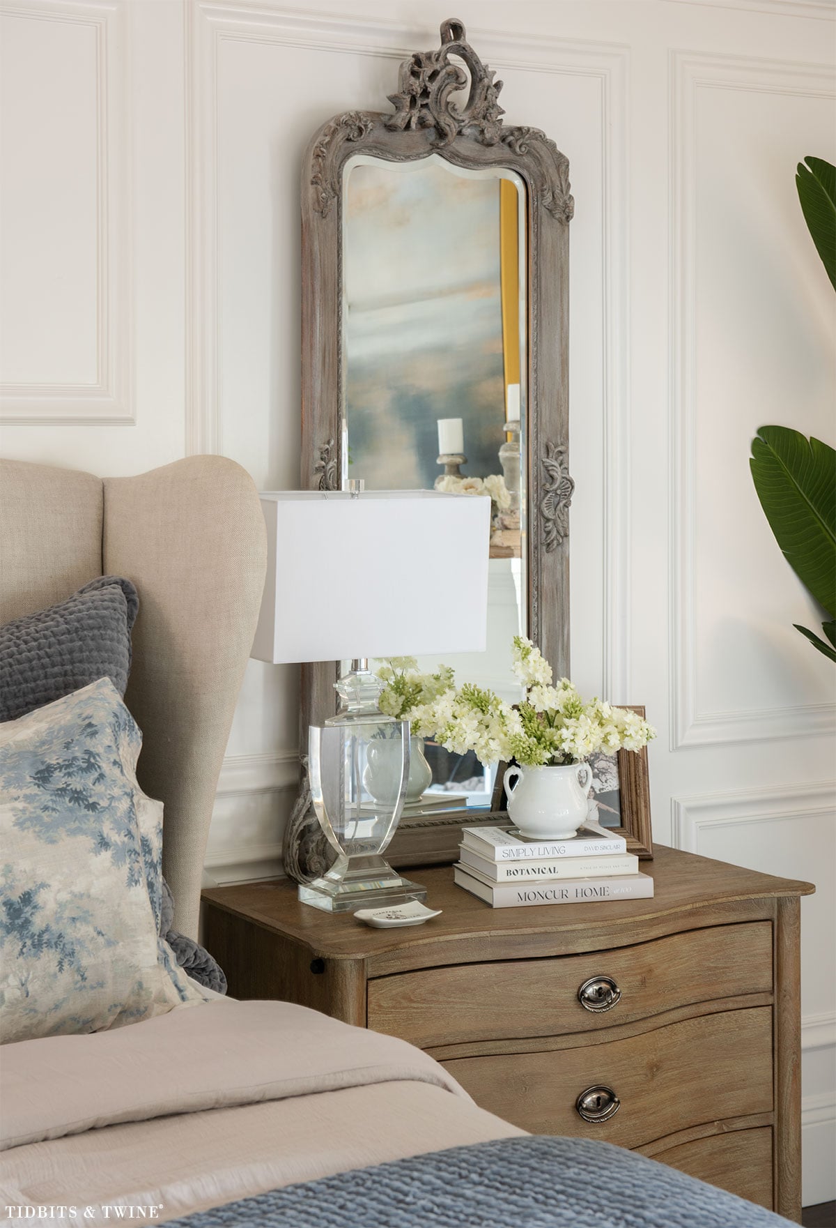 Nightstand decorating with mirror anchor behind lamp and styled bedside table