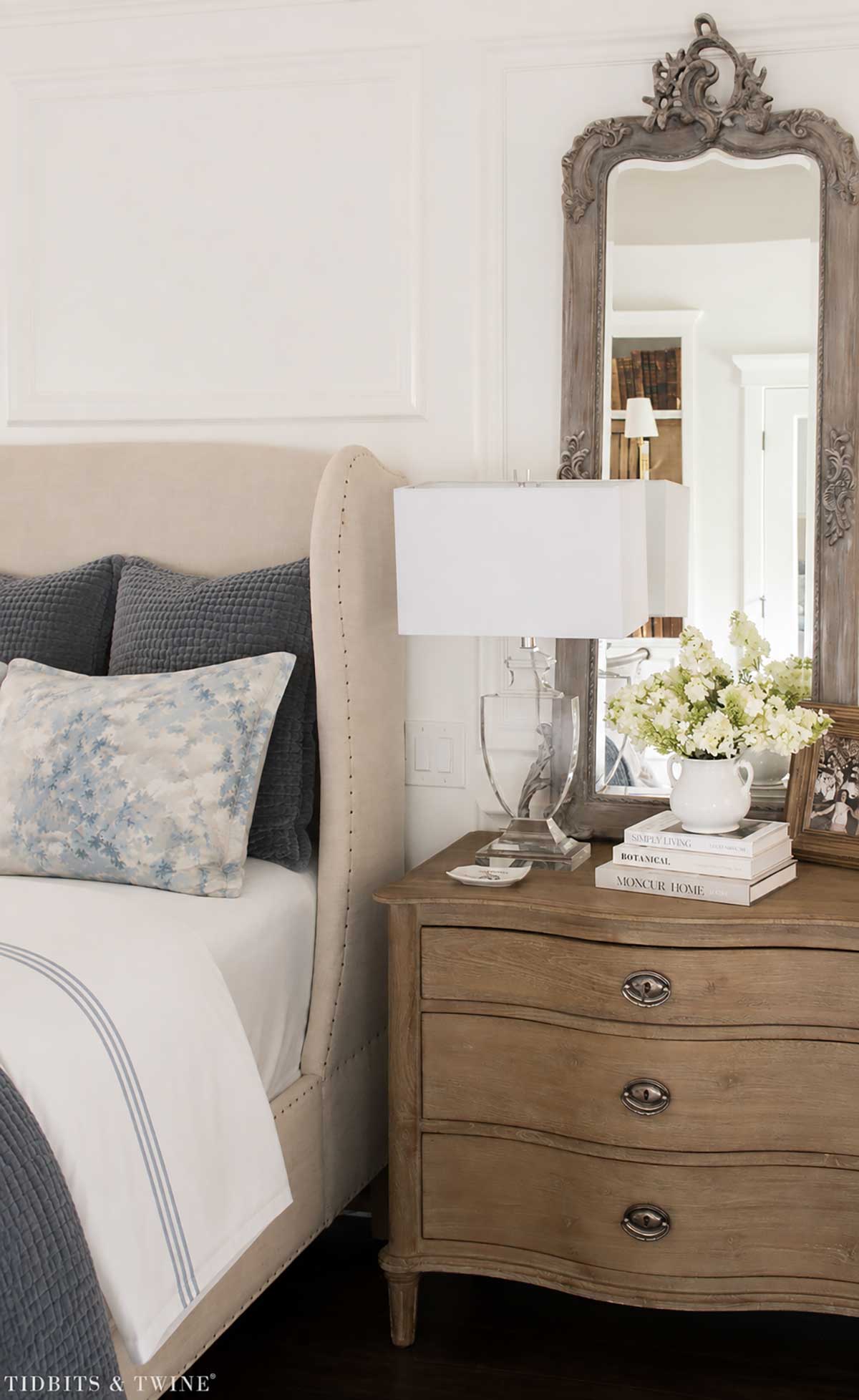 White cotton sheets with blue hotel-style banding on a neatly made bed
