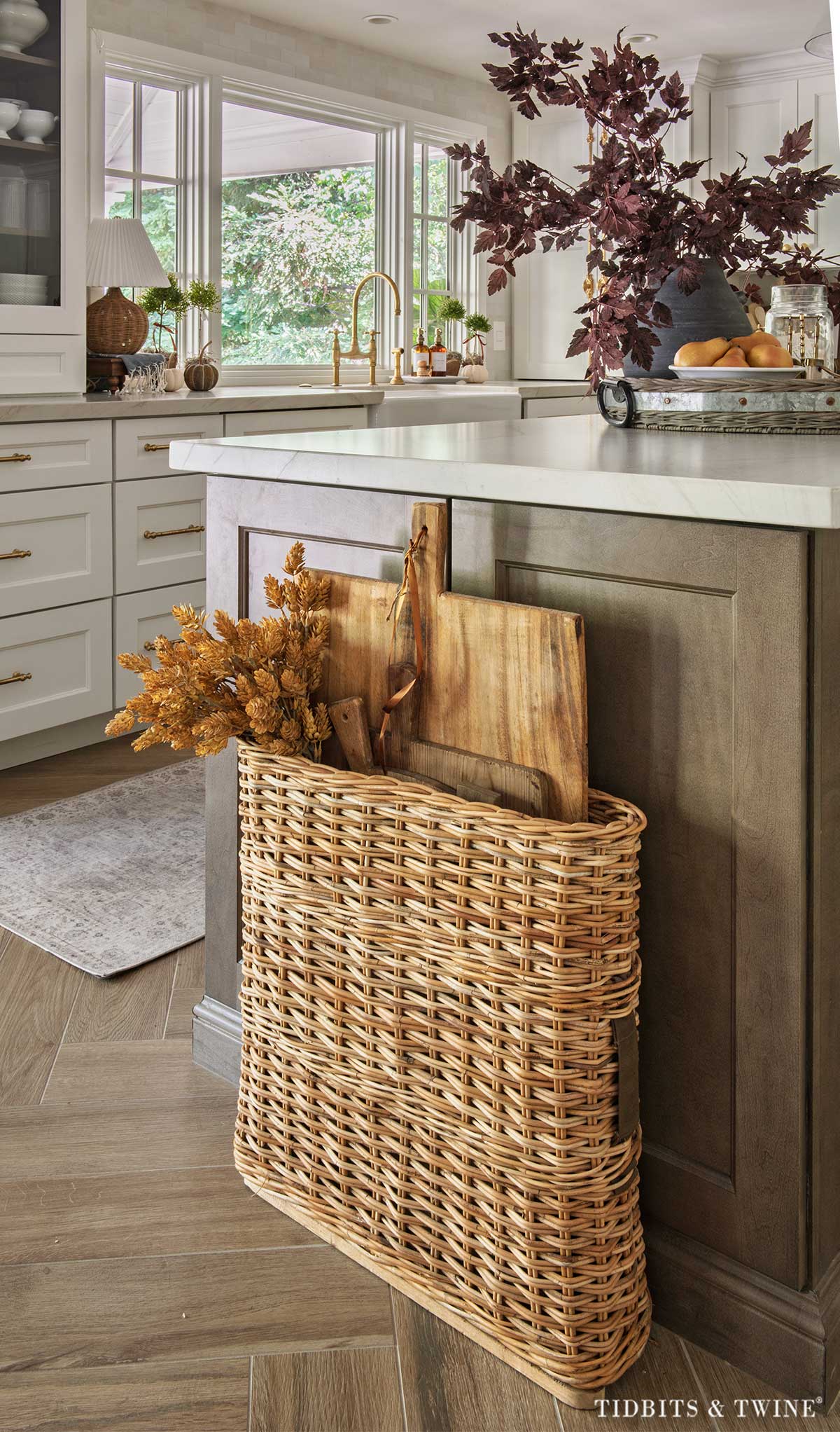 Vintage breadboards stored in an old ammunition basket beside a kitchen island