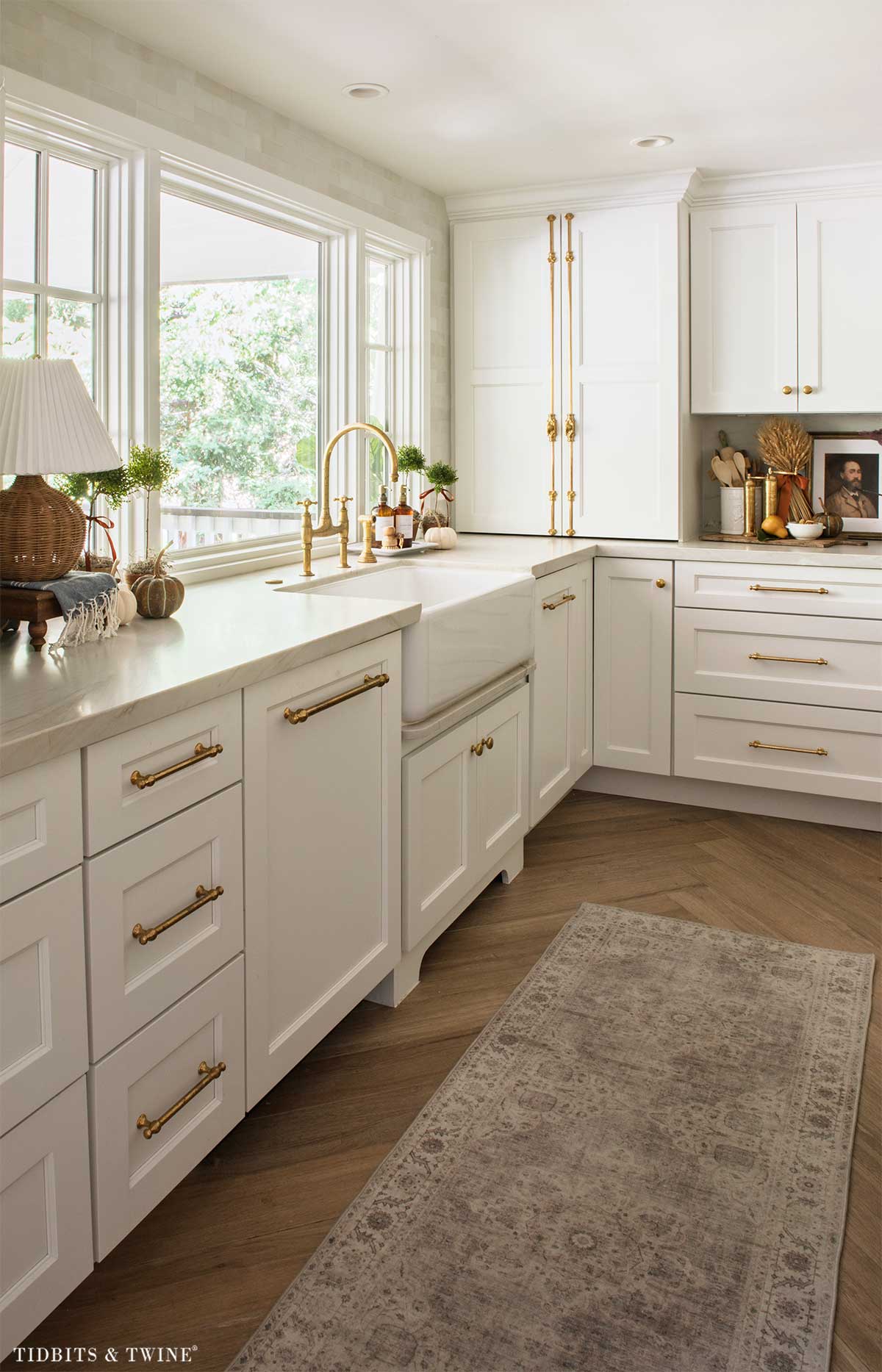 Fall kitchen sink area with topiaries, small pumpkins and brass fixtures