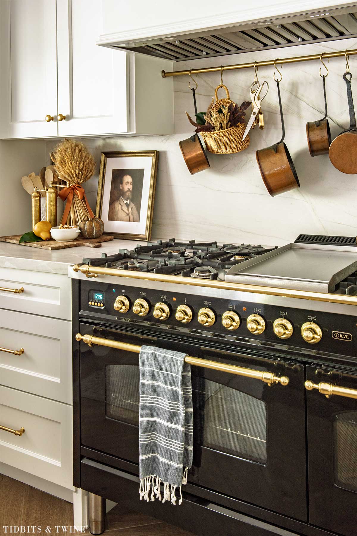 Black and brass range decorated for fall with wheat, vintage brass and an antique portrait