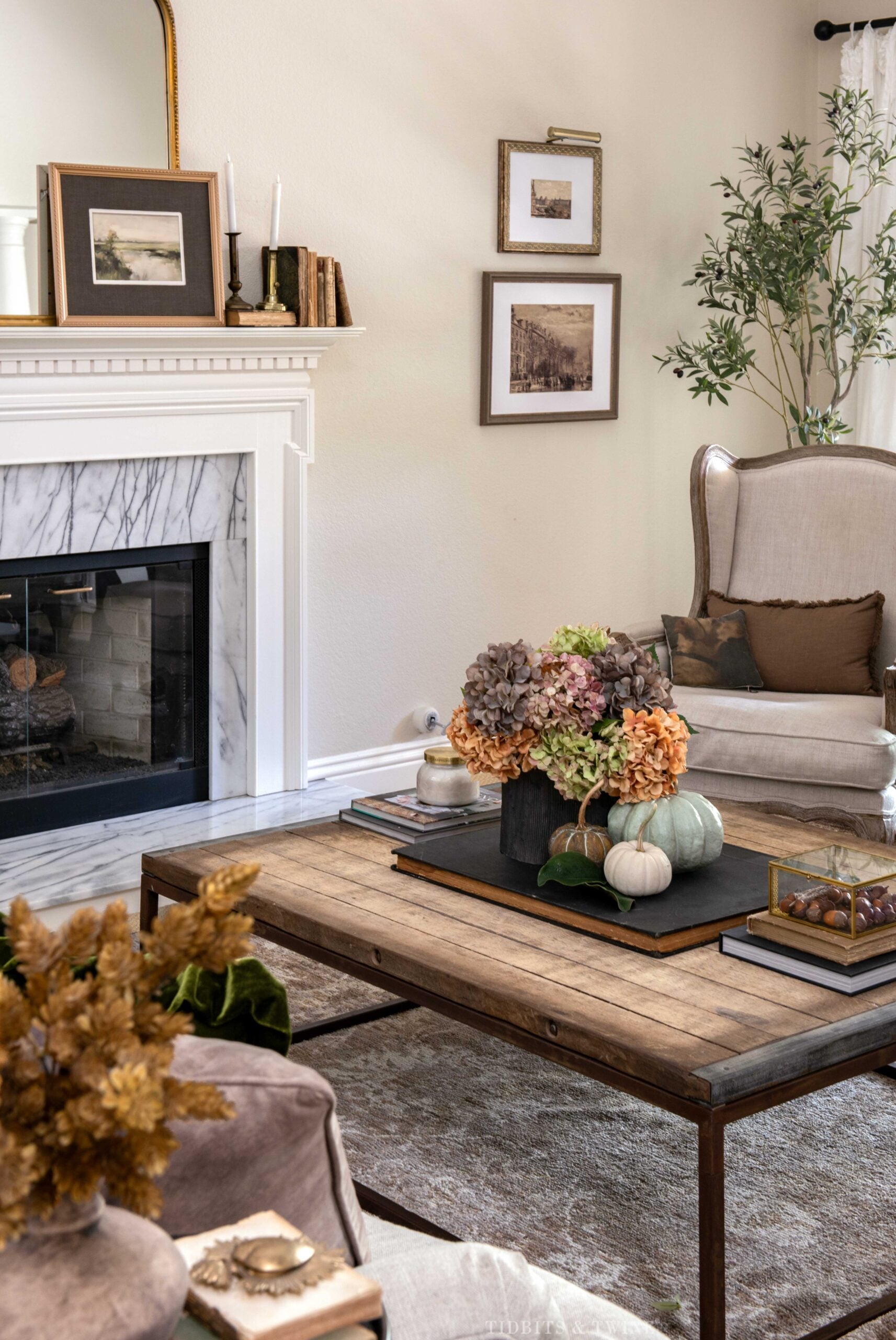 Fall living room with hydrangeas and pumpkins on a rustic wood coffee table